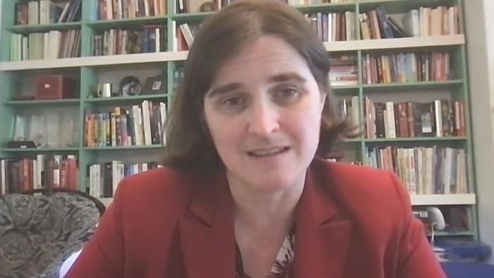 Alexandra Greenhill, devant une bibliothèque pleine, lors d'une entrevue en visioconférence.