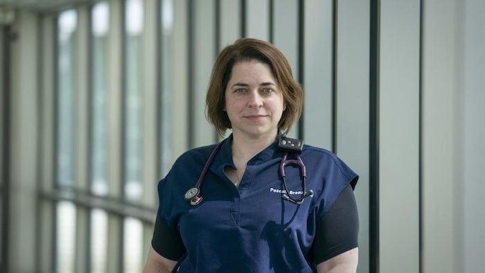Une médecin dans un corridor.