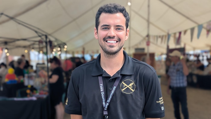 Médéric Clément pose devant un chapiteau de la Foire. 