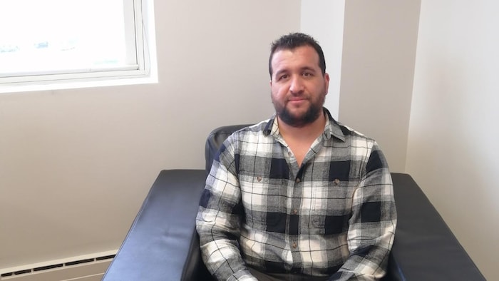Un homme assis, Mehdi Mehenni, rédacteur en chef du journal Le Voyageur.