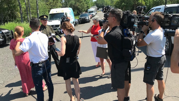 Un homme en entrevue avec plusieurs journalistes devant de nombreuses caméras.