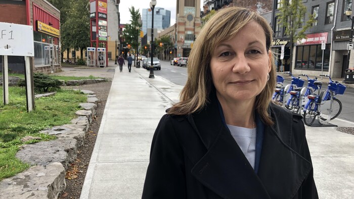 Une femme dans un manteau regarde la caméra, rue James, à Hamilton.