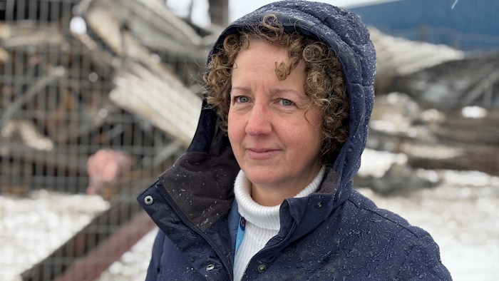 Mélanie Dorion sourit à la caméra. Un monticule de débris est visible derrière.