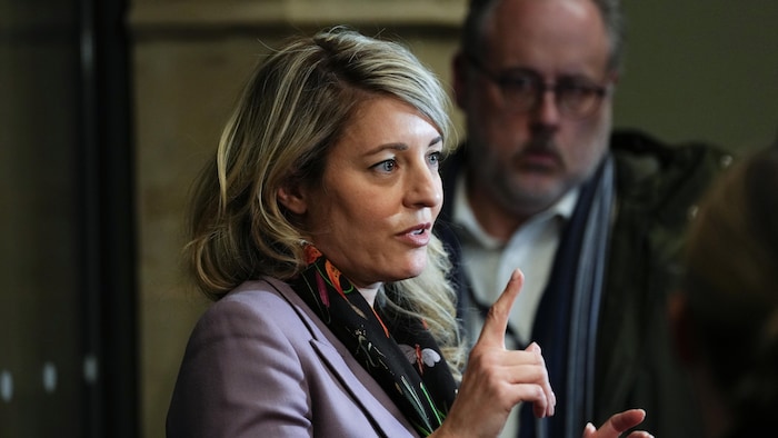 Mélanie Joly répond aux questions des journalistes en mêlée de presse au parlement canadien, le 3 mars 2025.