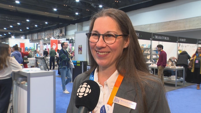 Mélanie Pelletier lors d'une entrevue avec Radio-Canada entre les kiosques du salon. 