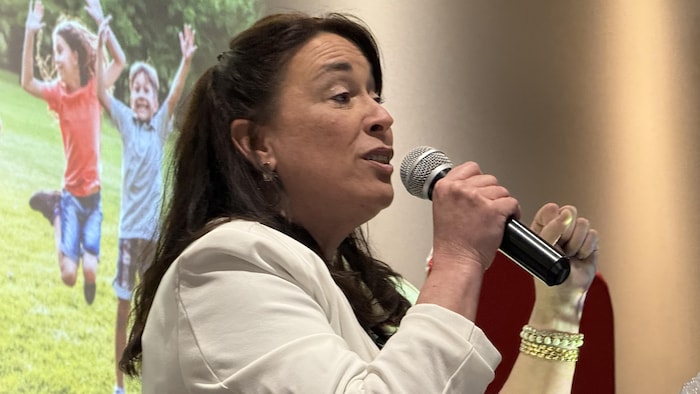 Mélanie Perreault parle dans un micro. 