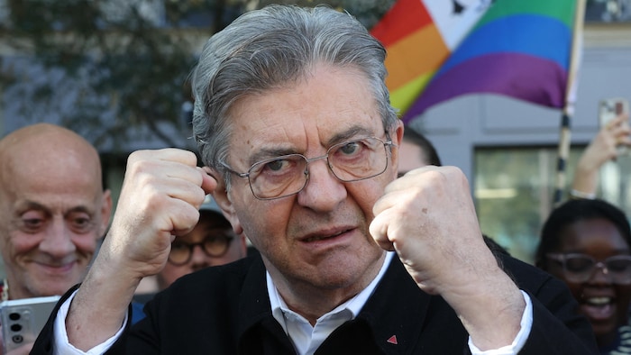 Un homme, les poings levés tel un boxeur, pose pour la photo.
