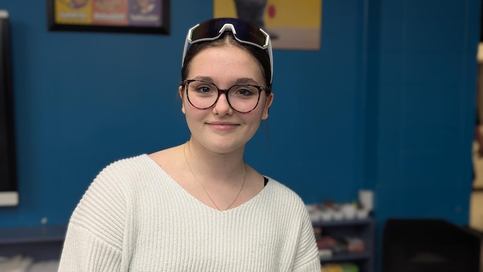 Mélia Mayer pose avec ses lunettes de soleil reçues sur la tête.