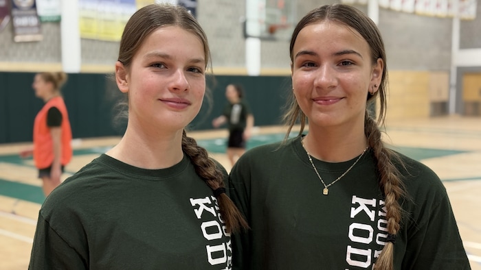 Deux filles sourient à la caméra.