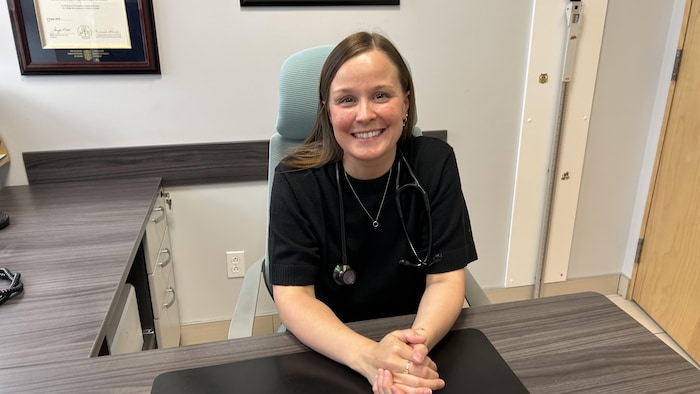 Une médecin assise dans son bureau. 
