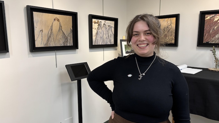 Mélissa Lacroix, souriante, devant des œuvres.