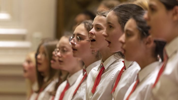 Des jeunes filles chantent en chœur.