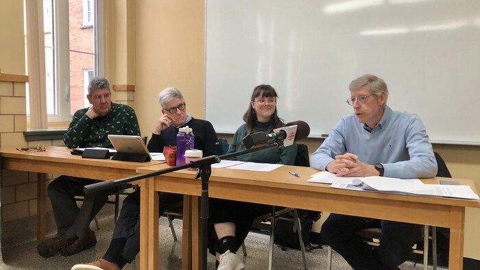 Les membres Comité de sauvegarde des Ateliers Saint-Louis à Rimouski assis à une table lors d'une conférence de presse.