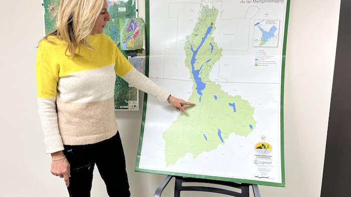Une femme pointe un endroit sur une carte géographique.