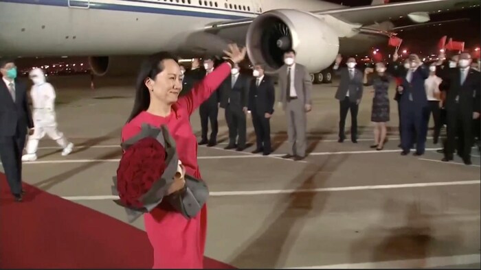 مينغ وانتشو العائدة من كندا، حيث كانت قيد الإقامة الجبرية، تحيي مستقبليها في مطار شنجن الدولي في الصين في أيلول (سبتمبر) 2021.