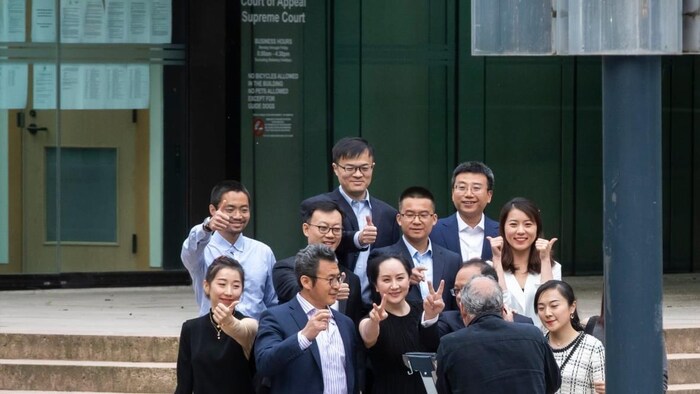 Meng Wanzhou, entourée de proches, fait le signe de la victoire devant le bâtiment de la Cour suprême de la Colombie-Britannique, samedi le 23 mai.
