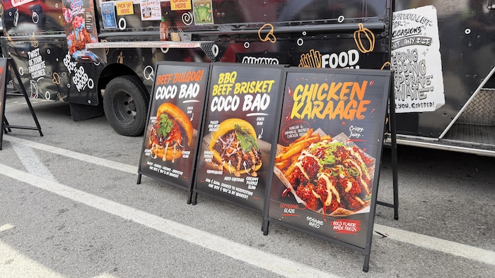 Trois panneaux de menu générés par l'IA au CNE de Toronto.