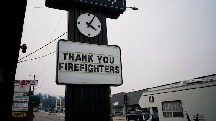 Une énorme affiche devant un commerce qui dit, en anglais, « Merci, les pompiers ».