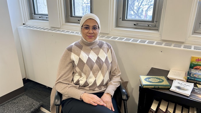 Meriem El Attar, assise dans la salle de prière de l’Université Laurentienne, avec le Coran à ses côtés.
