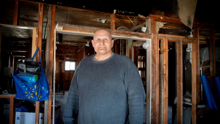 Sean Brown dans sa maison dont il ne reste que les montants de bois.