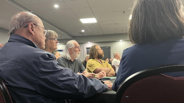 Des citoyens assis autour d'une table durant la consultation.