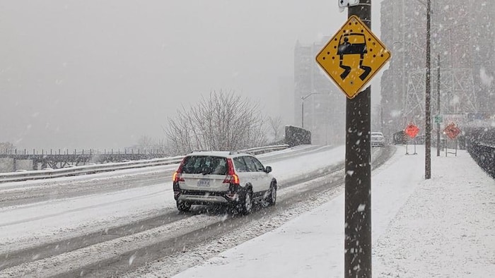 Une voiture sur une route enneigée.