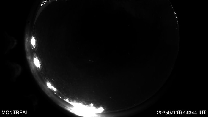 Photo noir et blanc d'une longue traînée lumineuse.