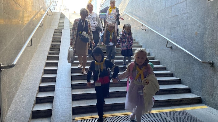 Des enfants descendent des escaliers.