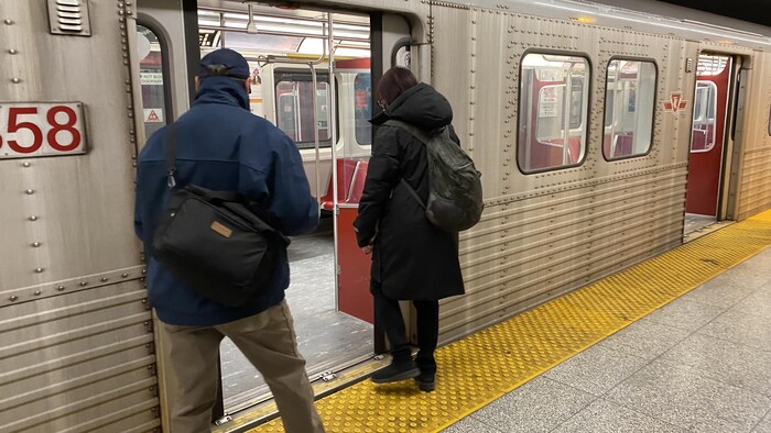 Deux usagers montent à bord d'une rame de métro.
