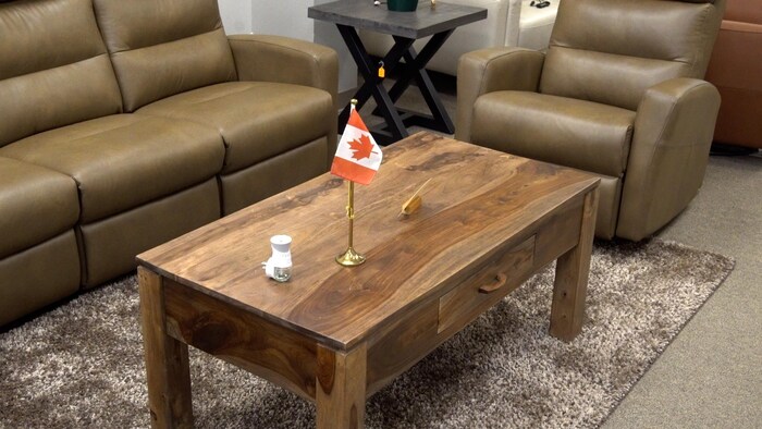 Une table basse en bois avec un petit drapeau canadien déposé au-dessus.
