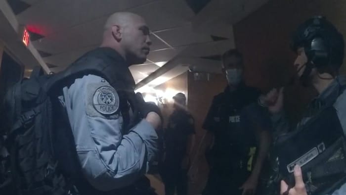 Des membres de l'Unité d'Intervention d'Urgence dans le couloir d'un immeuble transformé en refuge pour sans-abris.