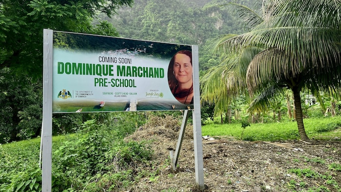 Un panneau avec un gros plan du visage souriant de Dominique Marchand annonce l'ouverture d'une école maternelle.