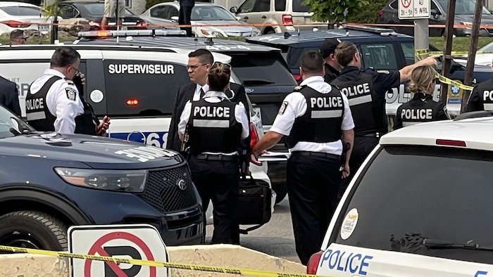 Des policiers discutent sur la scène du crime.