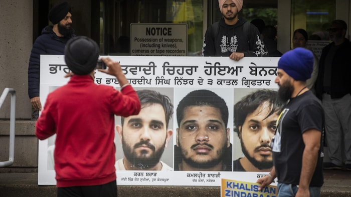 Des partisans du militant sikh assassiné en Colombie-Britannique, Hardeep Singh Nijjar, tiennent une pancarte avec le visage des accusés, le 7 mai 2024.