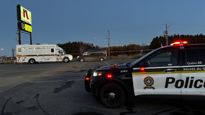 Une voiture et un camion de police dans un stationnement.