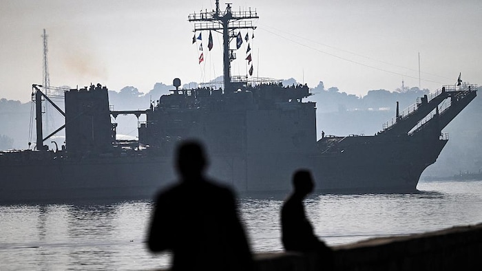 Des personnes regardent le navire dans la baie.