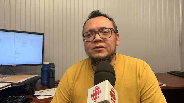 Un homme parle au micro pour une entrevue radio.