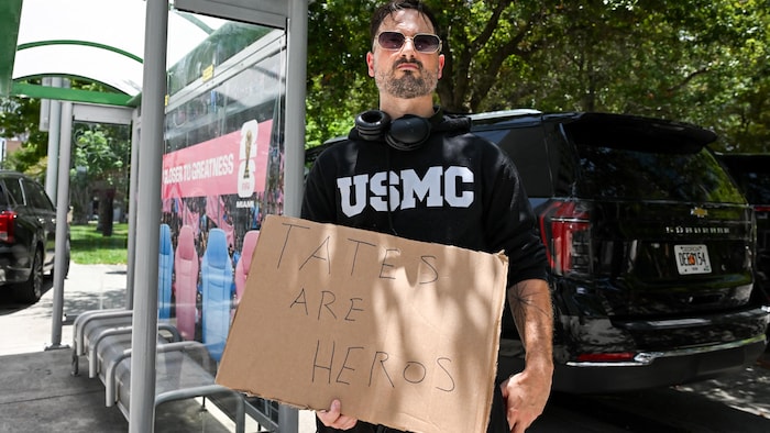Un homme tient une pancarte en carton.