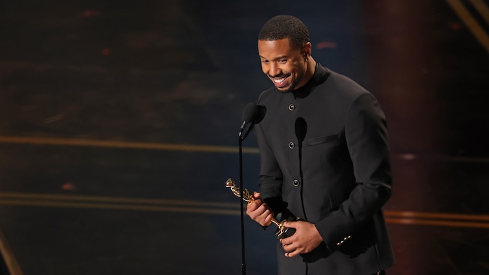 Un homme tient une statuette.