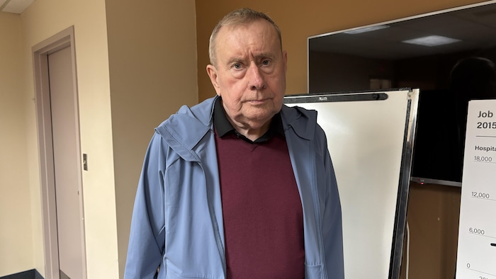 Michael Early porte une veste à capuchon et un chandail à col.