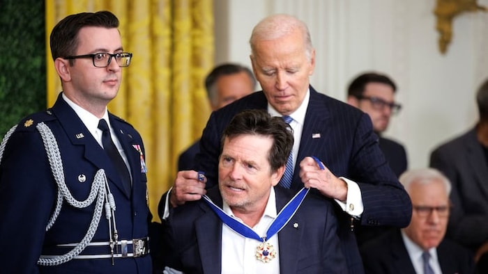 Joe Biden dépose autour du cou de Michael J. Fox la Médaille présidentielle de la Liberté.