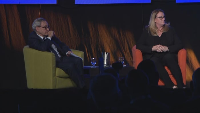 Michael Sabia et Jennifer Williams assis dans des fauteuils sur une scène.