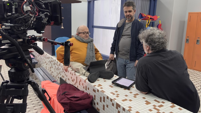 Trois hommes autour d'une array  avec des micros et caméras.