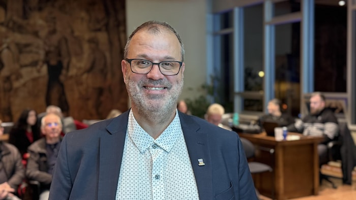 Le maire de Baie-Comeau est souriant devant ses partisans.