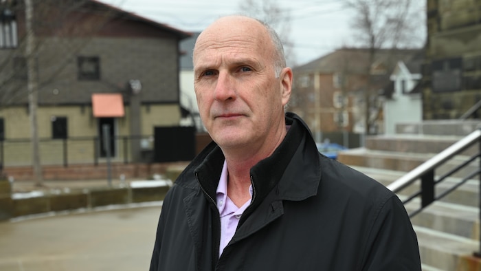 Michel Desjardins pose pour la photo à l'extérieur de la cathédrale de Moncton. 