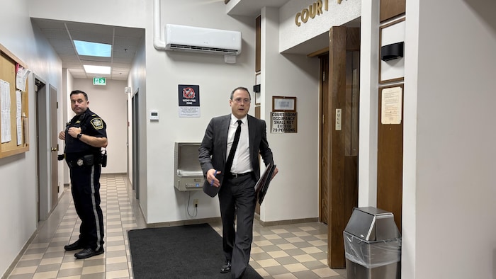 Un avocat avec un veston et une cravate grise.