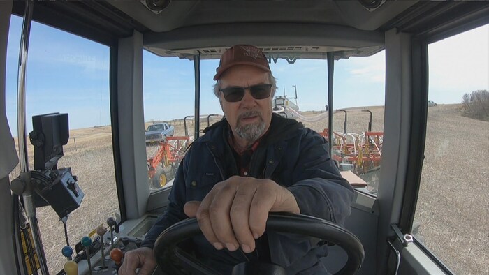 Au volant de son tracteur, Michel Lepage ensemence un champ.