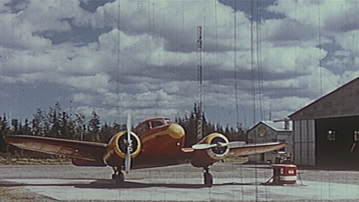 Photo d'archives d'un avion stationné devant un hangar.