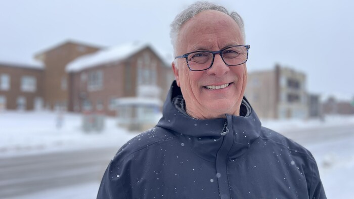 Un homme prend la pose pour la photo dehors en hiver. 