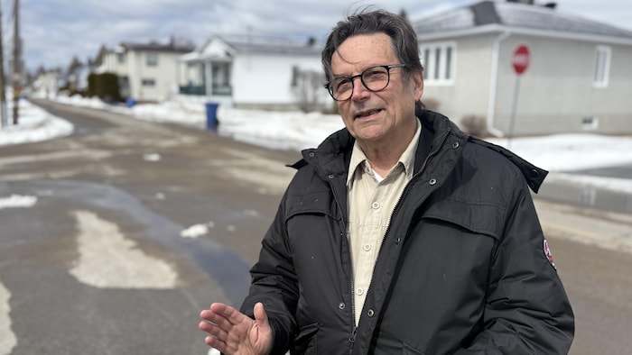 Un homme est debout à l’extérieur en hiver.